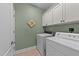 This laundry room has tile floor, full sized appliances, and upper cabinets for storage at 232 Shady Hollow Ln, Garner, NC 27529