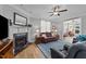 Cozy living room with a fireplace, comfortable leather seating, ceiling fan, and stylish decor, with hardwood floors at 232 Shady Hollow Ln, Garner, NC 27529