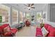Bright sunroom filled with natural light, comfortable seating, tile floors, and views of the backyard under a ceiling fan at 232 Shady Hollow Ln, Garner, NC 27529