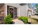 Inviting front porch with a decorative wreath, stone accents, and manicured landscaping at 2406 Lily Dr, Haw River, NC 27258