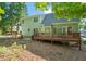 Expansive backyard with a wooden deck, stone patio, and fire pit for outdoor living at 2408 Fordcrest Dr, Apex, NC 27502