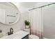 Bright bathroom with a round mirror, stylish fixtures, and a shower with a decorative curtain at 2408 Fordcrest Dr, Apex, NC 27502
