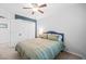 Cozy bedroom features a green striped bedspread, accent wall, a ceiling fan, and a closet at 2408 Fordcrest Dr, Apex, NC 27502