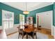 Dining room with teal walls, natural light, and wood table plus wine cabinet at 2408 Fordcrest Dr, Apex, NC 27502