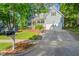 Charming home with a two-car garage and inviting front porch, nestled amongst lush trees, creating a serene, private ambiance at 2408 Fordcrest Dr, Apex, NC 27502