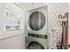 Modern laundry room with a stacked washer and dryer set, and geometric patterned walls at 2408 Fordcrest Dr, Apex, NC 27502