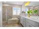 Elegant bathroom with a soaking tub, glass shower, dual vanities, and modern lighting fixtures for a spa-like experience at 249 Salt Cedar Ln, Chapel Hill, NC 27516