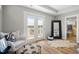Bright bedroom with a balcony walkout, comfortable sitting chair, and a view into the luxurious ensuite bathroom at 249 Salt Cedar Ln, Chapel Hill, NC 27516