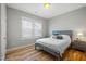 A cozy bedroom featuring hardwood floors, a queen-size bed, and a window providing natural light at 249 Salt Cedar Ln, Chapel Hill, NC 27516