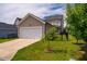 Charming home showcasing a two-car garage and a well-manicured front yard with a young tree at 249 Salt Cedar Ln, Chapel Hill, NC 27516