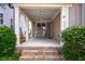 Inviting covered porch with rocking chairs, brick steps, and elegant columns at 249 Salt Cedar Ln, Chapel Hill, NC 27516
