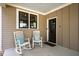 Cozy porch with rocking chairs and a stylish dark front door at 249 Salt Cedar Ln, Chapel Hill, NC 27516