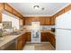 Efficient kitchen with white appliances and wood cabinets, perfect for functionality and style at 2519 Hitchcock Dr, Durham, NC 27705