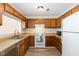 Kitchen with wooden cabinets, white appliances, and laminate countertops at 2519 Hitchcock Dr, Durham, NC 27705