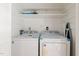 Bright laundry room featuring modern white appliances and shelves for storage at 2519 Hitchcock Dr, Durham, NC 27705