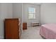 Cozy bedroom with carpet, a window, and a classic wooden dresser at 256 Rubrum Dr, Hillsborough, NC 27278