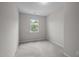 Clean bedroom with plush carpeting and a window overlooking mature trees at 256 Rubrum Dr, Hillsborough, NC 27278
