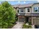 Townhome showcasing stone facade, garage, green front door, landscaping, and neutral siding at 256 Rubrum Dr, Hillsborough, NC 27278