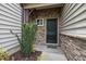 Close-up of the front door, showcasing stone facade and green door and a small garden at 256 Rubrum Dr, Hillsborough, NC 27278