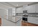 Modern kitchen with stainless steel appliances, white cabinetry and a granite island at 256 Rubrum Dr, Hillsborough, NC 27278