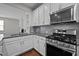 Bright kitchen with stainless steel appliances, gas range, and white cabinetry with granite countertops at 256 Rubrum Dr, Hillsborough, NC 27278