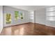 Bright living room with hardwood floors, built-in shelves, and a glass door to the outside at 256 Rubrum Dr, Hillsborough, NC 27278