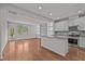Open-concept living area adjoining kitchen, hardwood floors, built-in shelving, and natural light at 256 Rubrum Dr, Hillsborough, NC 27278