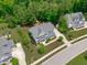 Aerial view of a two-story home with manicured landscaping, a long driveway, and mature trees at 2711 Jordan Pointe Blvd, New Hill, NC 27562