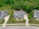 Aerial view showcasing the home's well-maintained lawn, landscaping, and proximity to a wooded area at 2711 Jordan Pointe Blvd, New Hill, NC 27562