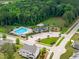 Beautiful aerial view of the community clubhouse, pool, playground, basketball court, and green spaces at 2711 Jordan Pointe Blvd, New Hill, NC 27562