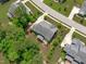 Aerial view of a well-maintained home with a backyard deck, lush landscaping, and surrounding greenery at 2711 Jordan Pointe Blvd, New Hill, NC 27562