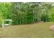 Expansive backyard with lush green grass, mature trees, and a charming swing set at 2711 Jordan Pointe Blvd, New Hill, NC 27562
