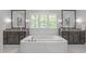 Elegant bathroom featuring a soaking tub, double vanities, and a large window at 2711 Jordan Pointe Blvd, New Hill, NC 27562