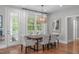 Dining room has hardwood floors, elegant lighting, and large windows with backyard views at 2711 Jordan Pointe Blvd, New Hill, NC 27562