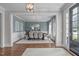 Elegant dining room featuring wainscoting, a modern chandelier, and seating for eight, perfect for Gathering gatherings at 2711 Jordan Pointe Blvd, New Hill, NC 27562