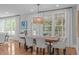 Dining room has hardwood floors, elegant lighting, and large windows with backyard views at 2711 Jordan Pointe Blvd, New Hill, NC 27562