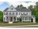 Beautiful two-story home with a manicured lawn and charming curb appeal, complemented by black shutters and a welcoming porch at 2711 Jordan Pointe Blvd, New Hill, NC 27562