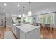 Bright kitchen open to living room and dining room, features white cabinets and marble countertops at 2711 Jordan Pointe Blvd, New Hill, NC 27562