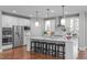 Bright kitchen features a large island with seating, pendant lighting, and stainless steel appliances at 2711 Jordan Pointe Blvd, New Hill, NC 27562
