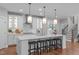 Bright kitchen features a large island with seating, pendant lighting, and stainless steel appliances at 2711 Jordan Pointe Blvd, New Hill, NC 27562