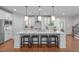 Bright kitchen features a large island with seating, pendant lighting, and stainless steel appliances at 2711 Jordan Pointe Blvd, New Hill, NC 27562