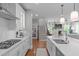 Bright kitchen leads to staircase and living area, features white cabinets and marble countertops at 2711 Jordan Pointe Blvd, New Hill, NC 27562