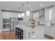 Bright kitchen features a large island with seating, pendant lighting, and stainless steel appliances at 2711 Jordan Pointe Blvd, New Hill, NC 27562
