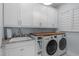 Laundry room with modern white cabinets, granite counters, and a washer and dryer at 2711 Jordan Pointe Blvd, New Hill, NC 27562