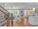 Open-concept living room with hardwood floors, a ceiling fan, and large windows that offer an abundance of natural light at 2711 Jordan Pointe Blvd, New Hill, NC 27562