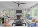 Bright living room features a fireplace, a ceiling fan, and comfortable seating with lots of light from the many windows at 2711 Jordan Pointe Blvd, New Hill, NC 27562