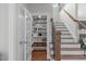 Pantry area with display shelving, wine storage, and storage baskets by the stairs at 2711 Jordan Pointe Blvd, New Hill, NC 27562