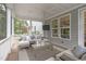 An enclosed porch boasts comfortable seating, a ceiling fan, and a mounted TV at 2711 Jordan Pointe Blvd, New Hill, NC 27562
