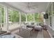 An enclosed porch boasts comfortable seating, a ceiling fan, and a mounted TV at 2711 Jordan Pointe Blvd, New Hill, NC 27562