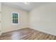Clean bedroom with wood-look flooring and a window overlooking a natural setting at 295 Rudd Rd, Youngsville, NC 27596